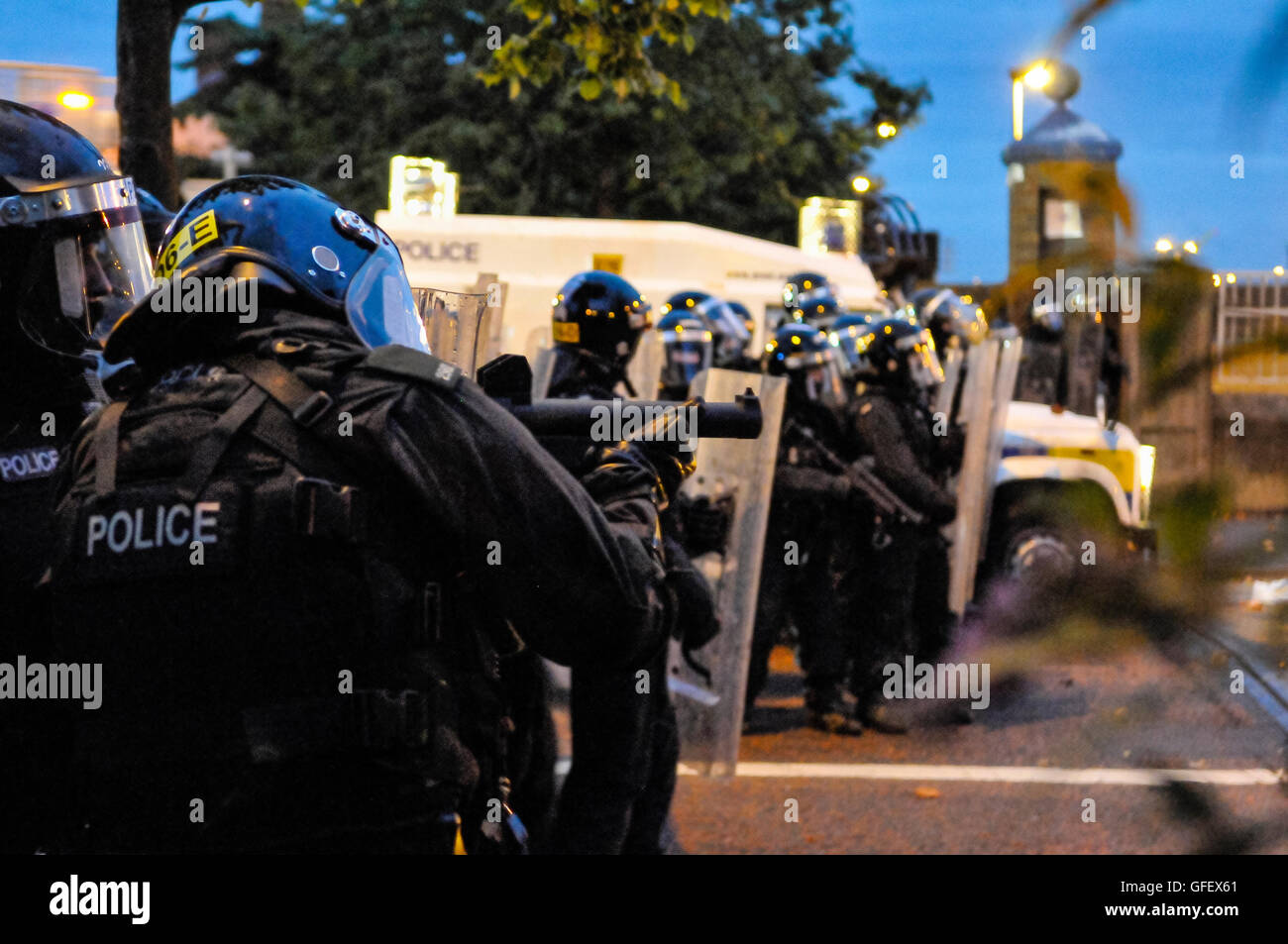 Belfast, Northern Ireland. 9th August 2013 - A PSNI Police officer aims a 'plastic bullet' gun at protesters during a loyalist riot. Stock Photo