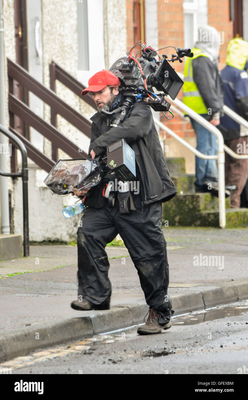Belfast, Northern Ireland. 18 Dec 2014 - A cameraman carries a movie quality video camera. Stock Photo