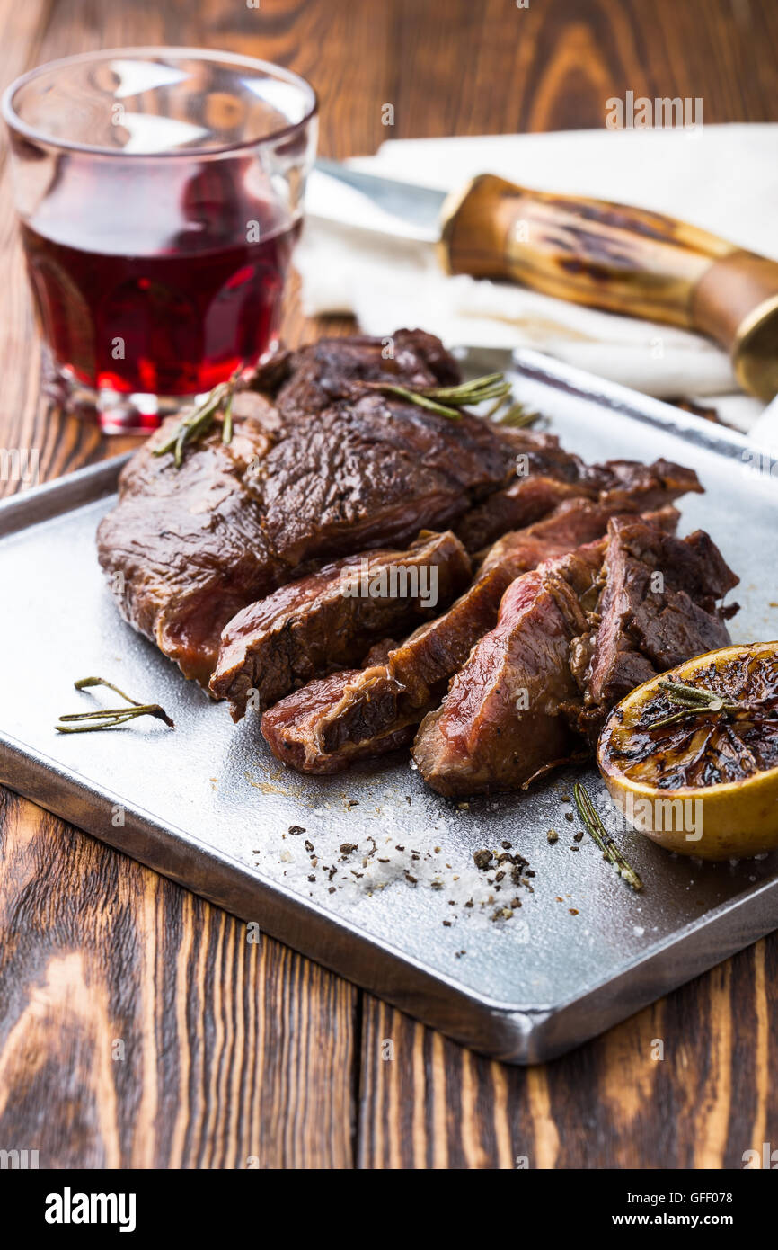 Medium rare grilled marinated beef flank steak on silver plate Stock