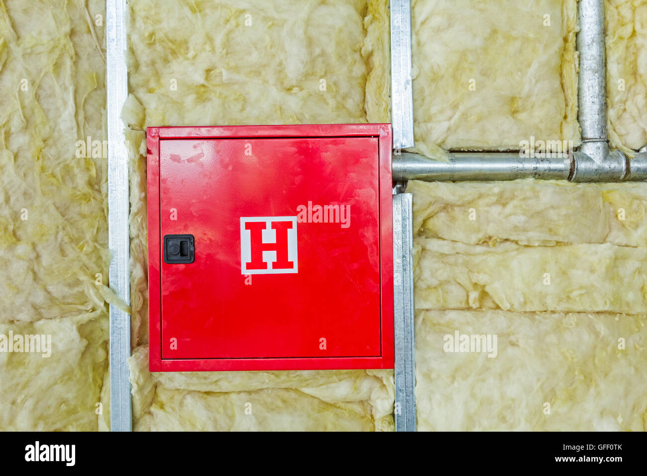 Front side of fire box with symbol for hydrant in an unfinished party wall. Stock Photo