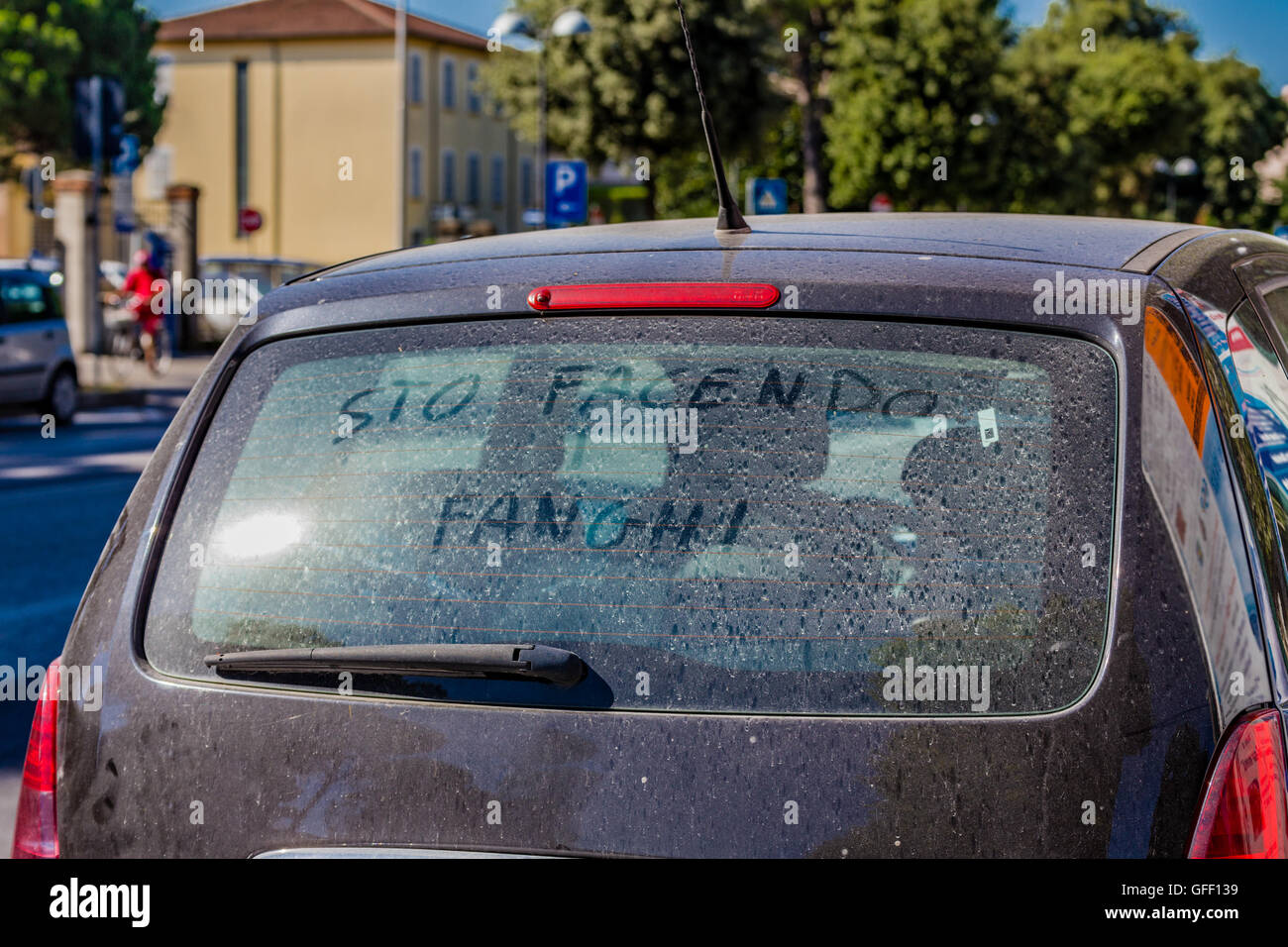 Italian sentence written for the purpose mocking on the heated rear window of a car dirty meaning I am taking mud bath Stock Photo