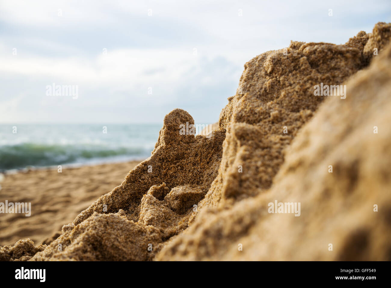 Closeup of a sand beach in evening light blurred blue sea with sky and cloud background, Selective focus Stock Photo