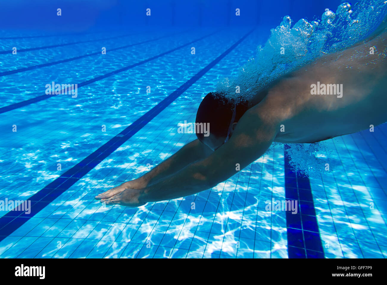 Jumping into the swimming pool underwater. Male swimmer at the swimming