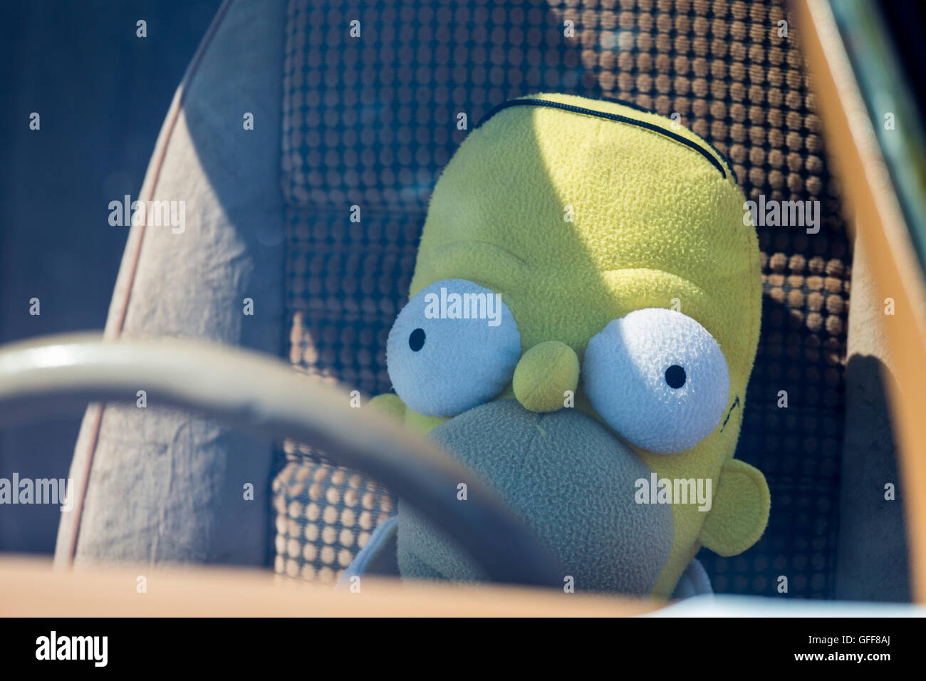 Homer Simpson soft toy doll behind the wheel of a car Stock Photo