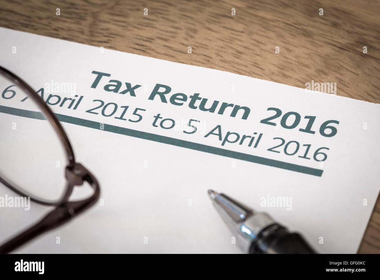 UK Income tax return form for 2016 on a desk with pen and glasses Stock Photo
