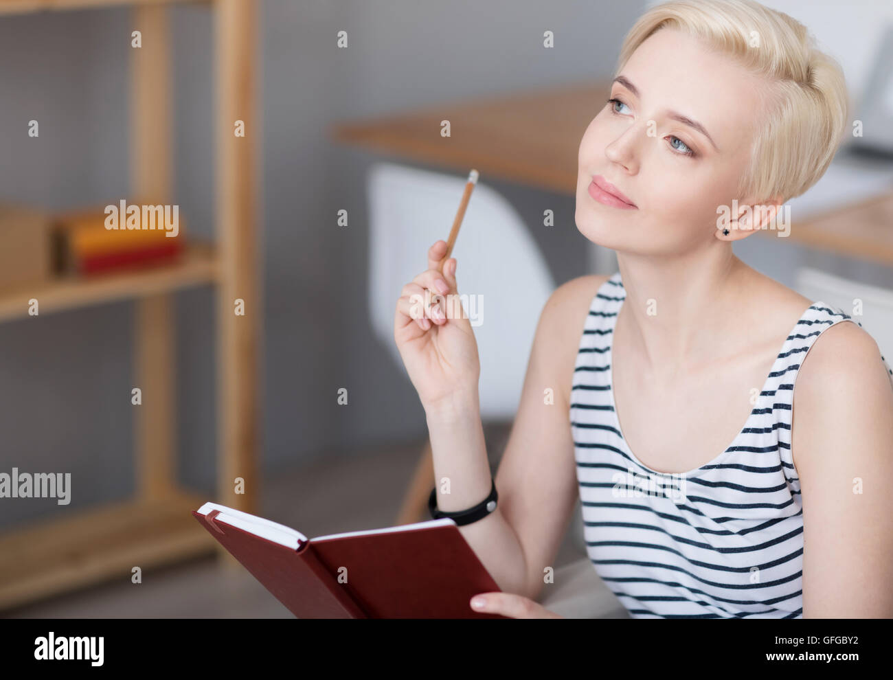 Woman thinking and holding diary Stock Photo