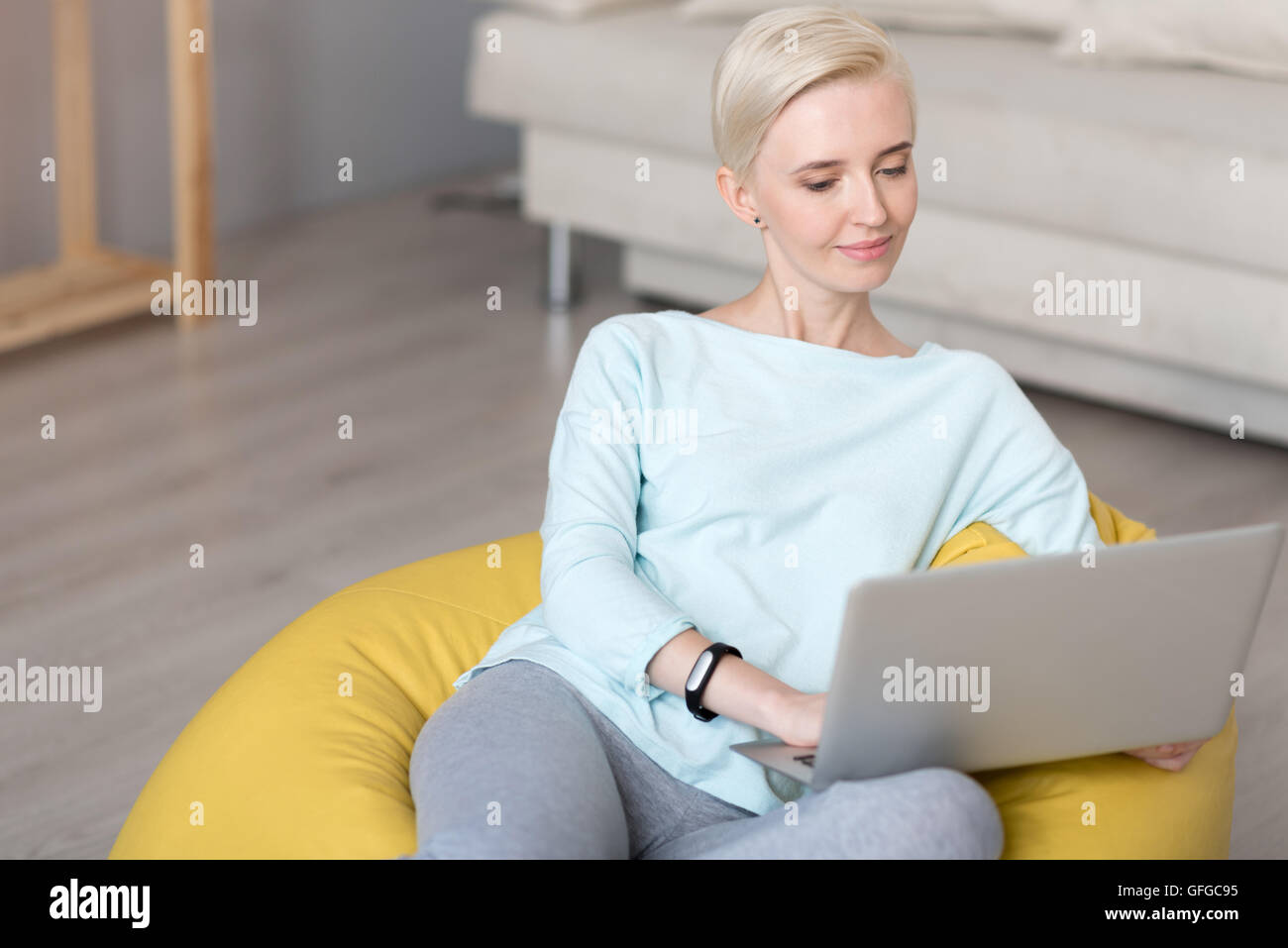 Relaxed woman using laptop while sitting Stock Photo - Alamy