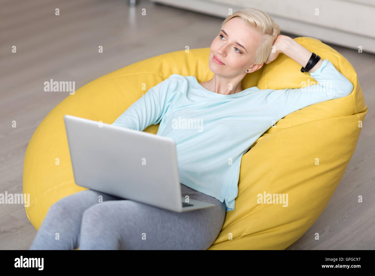 Woman sitting on bean bag and dreaming Stock Photo - Alamy