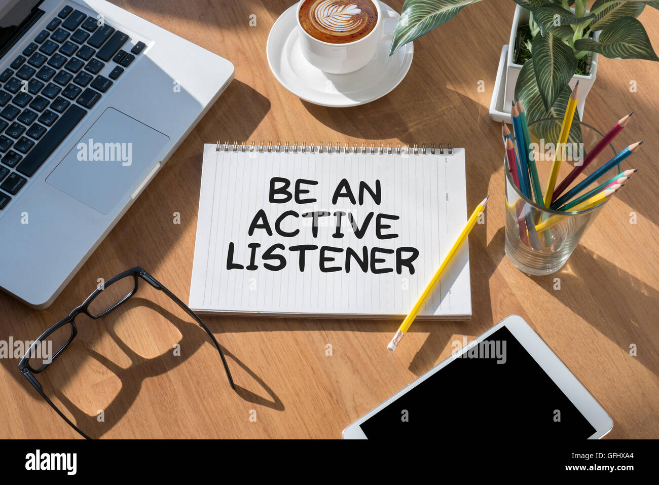 BE AN ACTIVE LISTENER open book on table and coffee Business Stock Photo