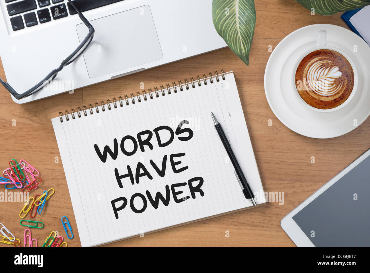 Words Have Power Tablet with blank black screen and coffee cup Stock Photo