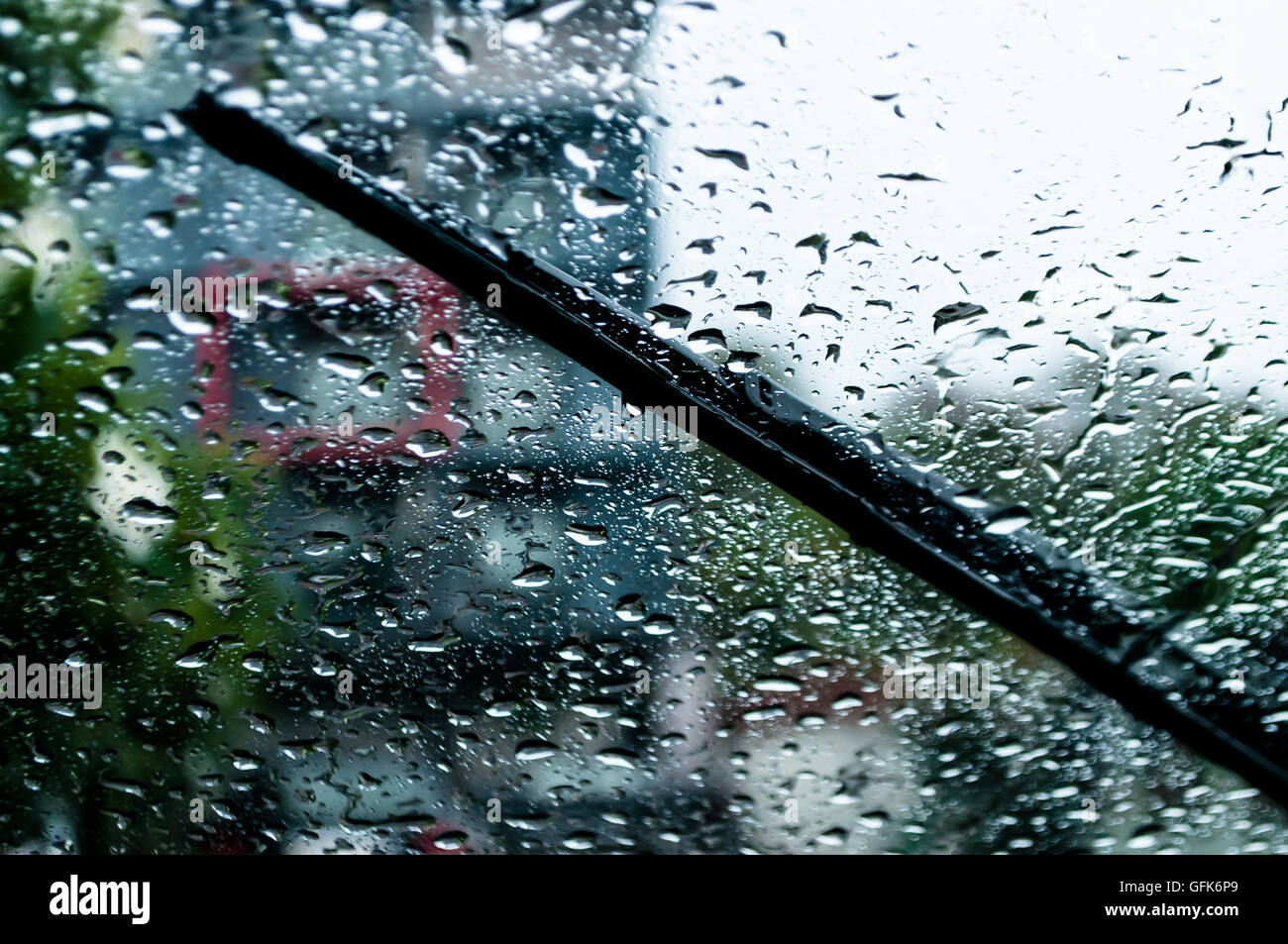 raindrops and wiper on car windshield. use wipers and drive slowly in