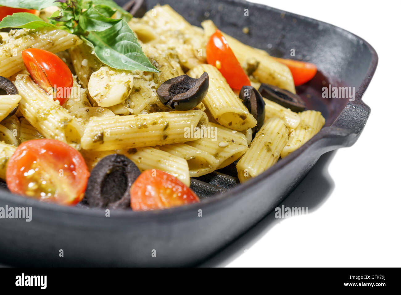 Penne pesto sauce pasta with grape tometo and black olive Stock Photo