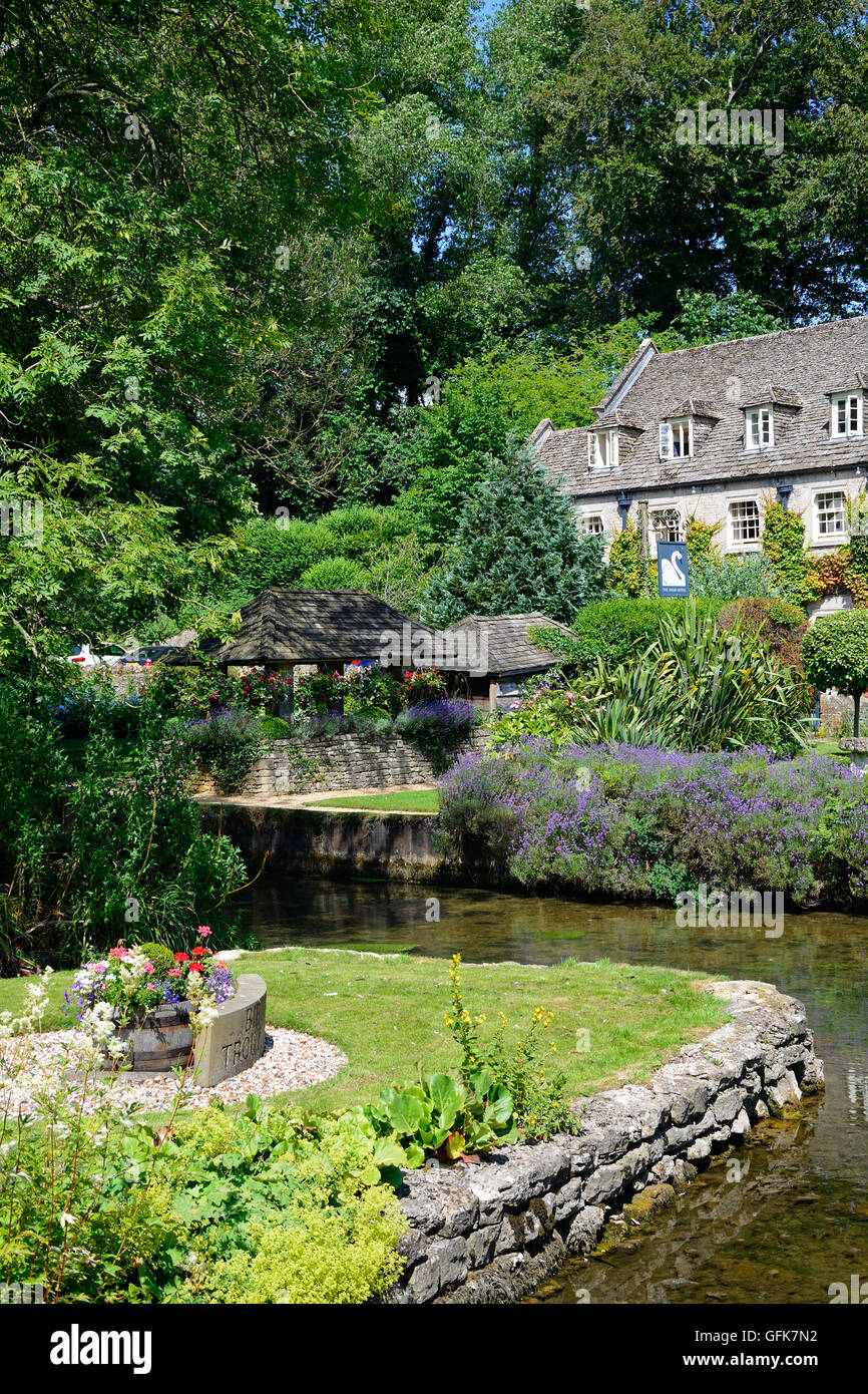 View across the trout farm garden and River Coln towards The Swan Hotel, Bibury, Cotswolds, Gloucestershire, England, UK. Stock Photo