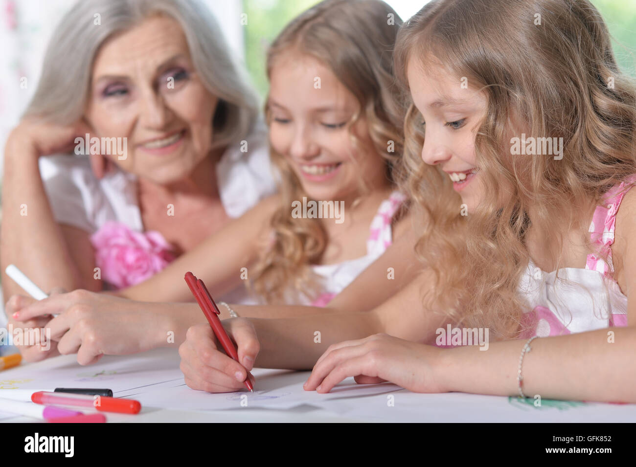Old woman with tweenie   girls drawing Stock Photo