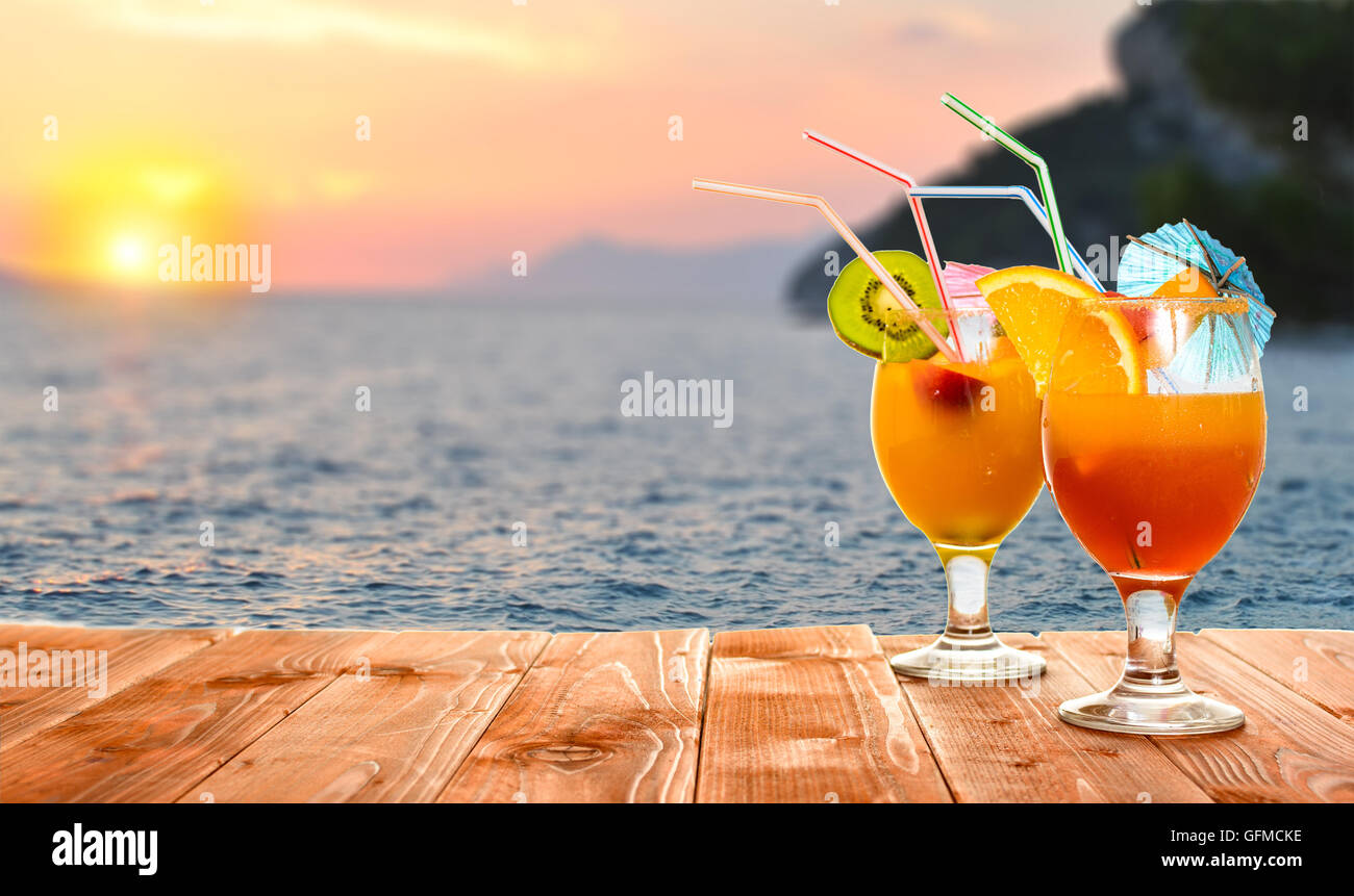 Summer fruit drinks or juice with ocean beach on background Stock Photo