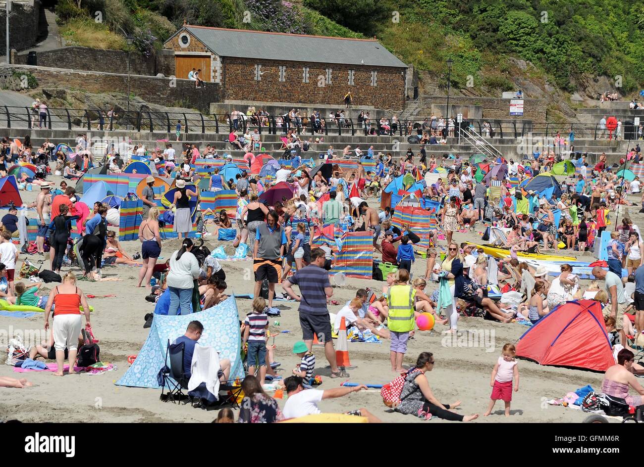 Looe beach, Cornwall, UK. Tourists enjoy the weather at Looe beach in ...