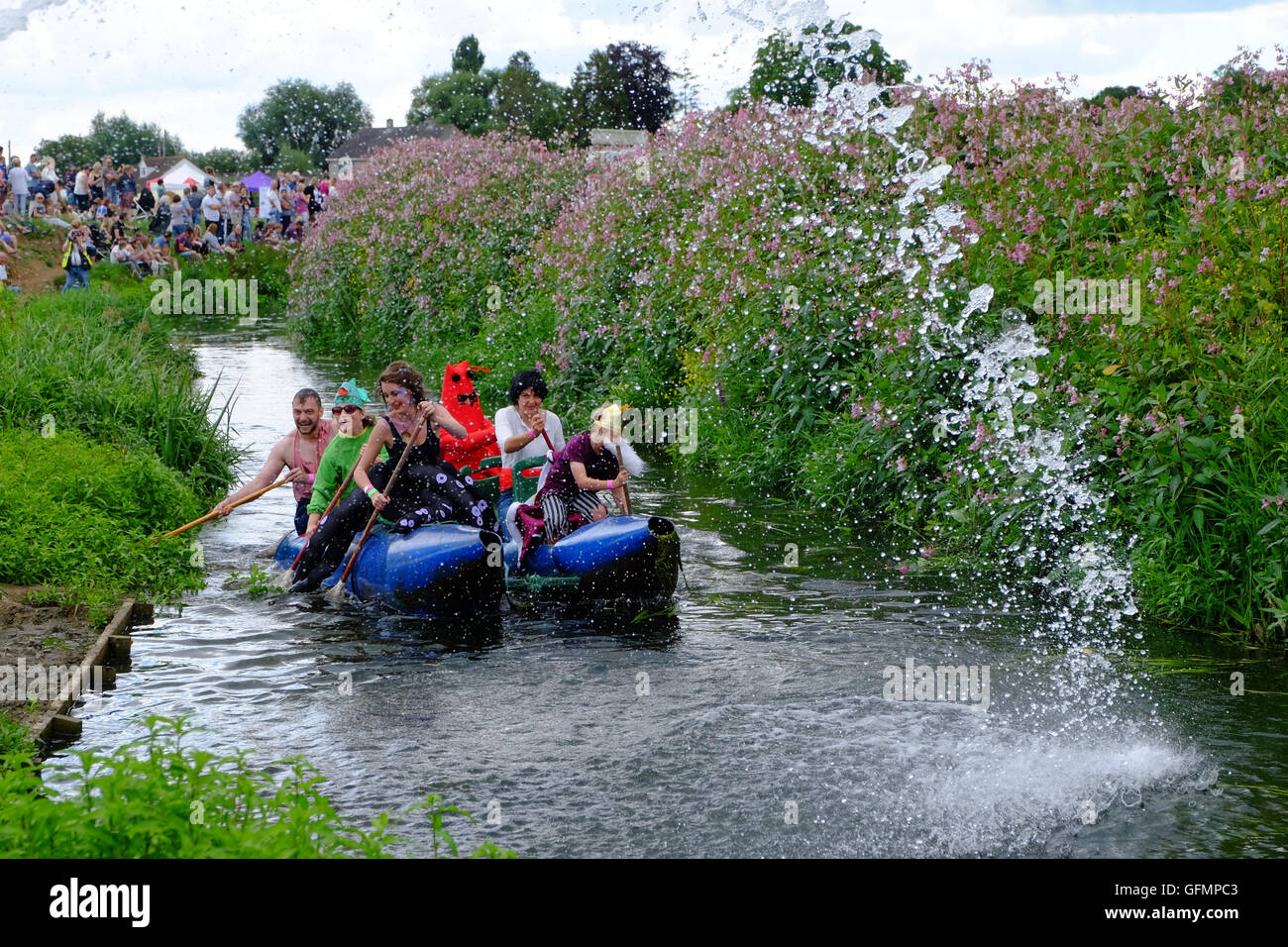 Lowland Games, Thorney, Somerset, UK. 31st July, 2016. Competitors take part in the annual Lowland Games Raft Race on the River Parrett in Somerset. Hundreds turned out in the heat to watch the Lowland Games which includes such events as Hay Bale Racing, Wife Carrying, River its a Knock Out, Mud Wrestling, and Chunder Challenge. The games, originally started in 1984, are held annually in the Lowland village of Thorney which became flooded for the first time in centuries during the Somerset floods in January 2014 Credit:  Tom Corban/Alamy Live News Stock Photo