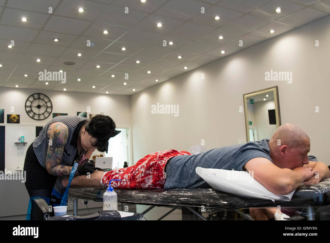 Rayleigh, Essex, UK. 31st July, 2016. Lee Ross of Colchester gets a tattoo of 'The Gimp Man of Essex' to raise funds for the mental health charity Colchester Mind. Credit:  David Johnson/Alamy Live News Stock Photo