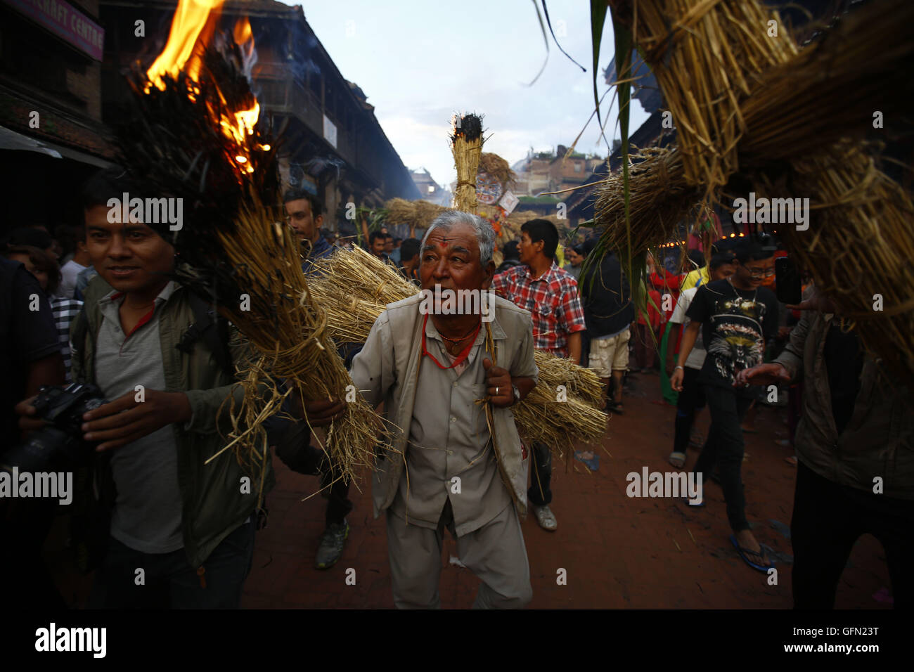 Bhaktapur, Nepal. 1st Aug, 2016. A Nepalese man carries straw to burn effigy of mythical demon Ghanta Karna as celebrations for his death during the Hindu festival of Gathe Mangal in Dattatreya Square, Bhaktapur, Nepal on Monday, August 1, 16. It is believed according to myths that by burning the demon rid evil spirits. © Skanda Gautam/ZUMA Wire/Alamy Live News Stock Photo