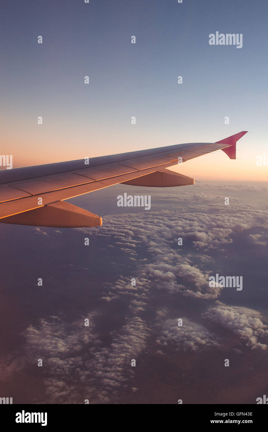 Airplane wing with sunrise in light flare Stock Photo - Alamy