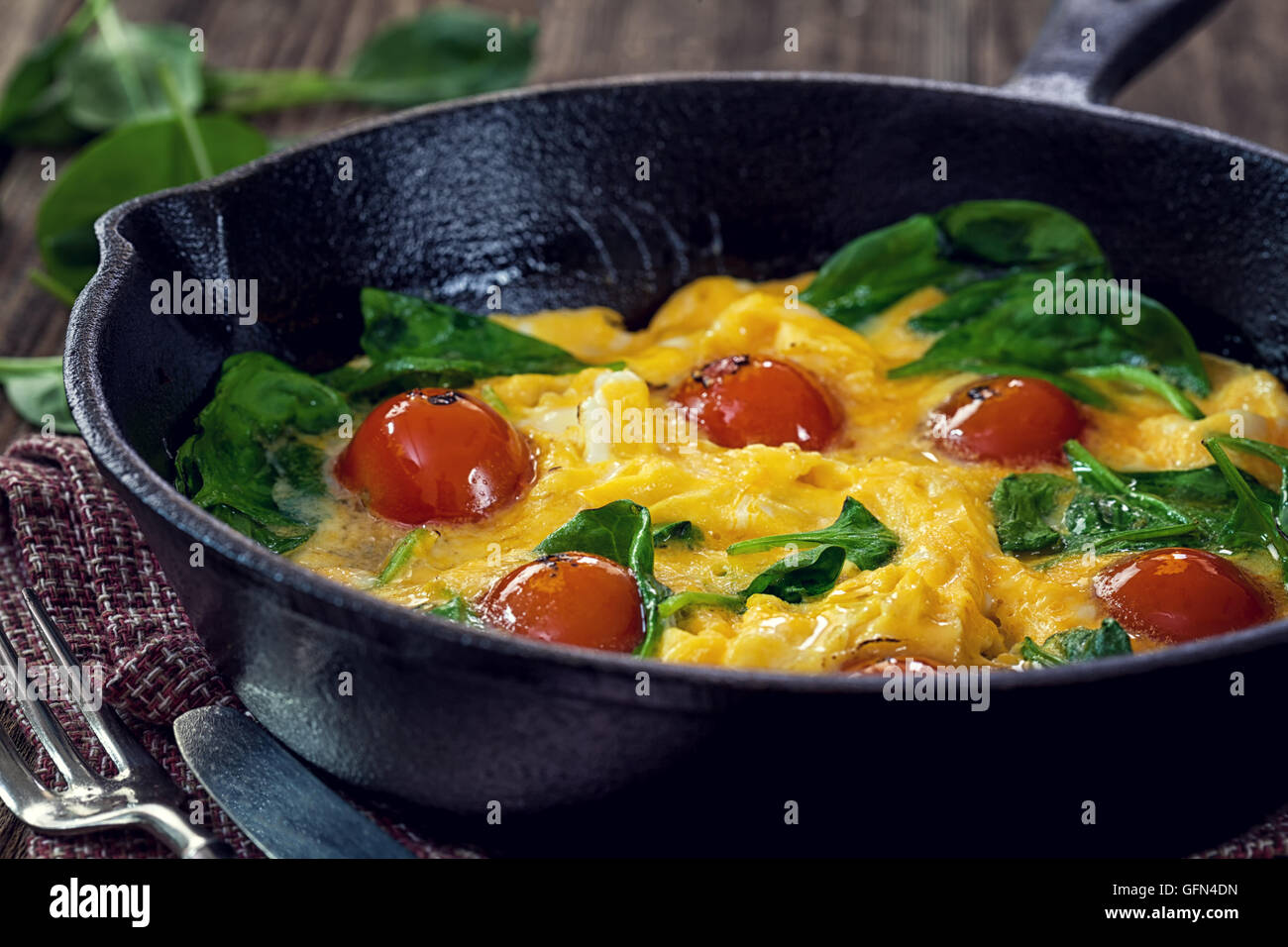 Spinach frittata with cherry tomato in iron skillet Stock Photo Alamy
