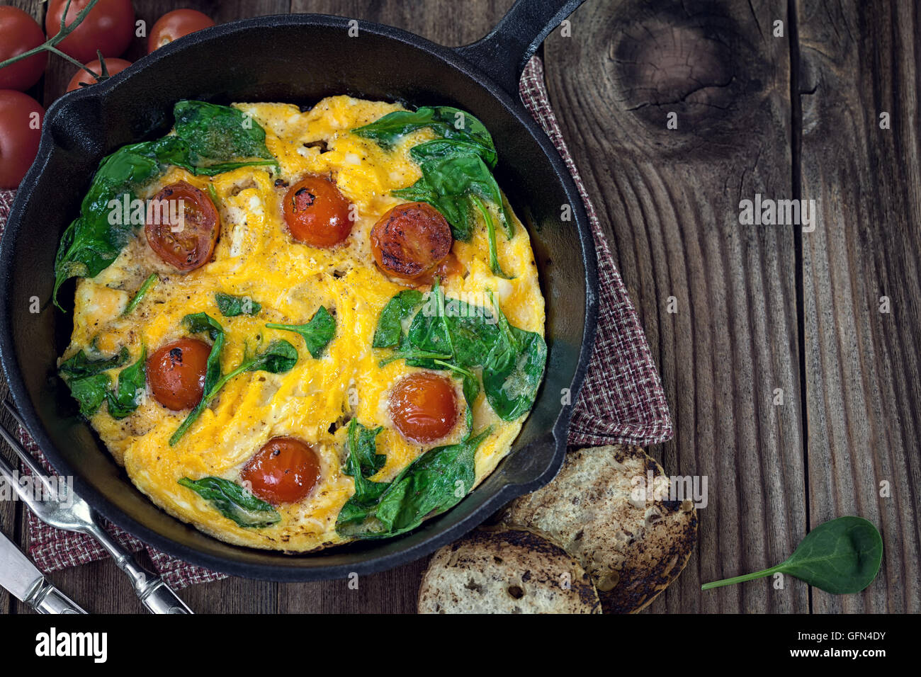 Spinach frittata with cherry tomato in iron skillet Stock Photo Alamy