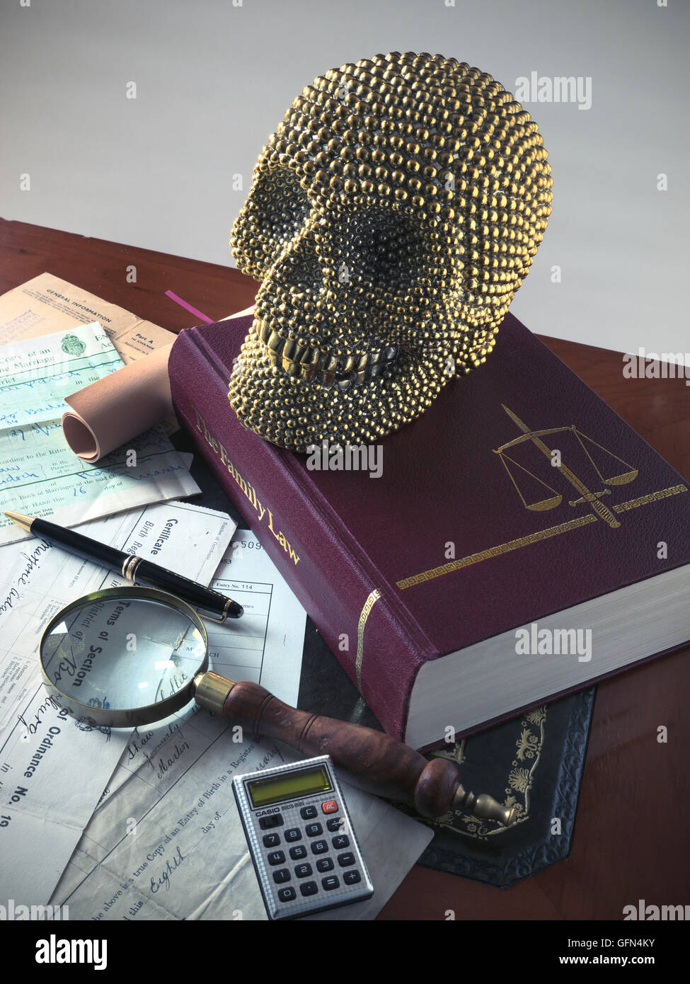 Legal Will last testament inheritance humour smiling gold human skull on Family Law book with various official legal probate family documents Concept Stock Photo