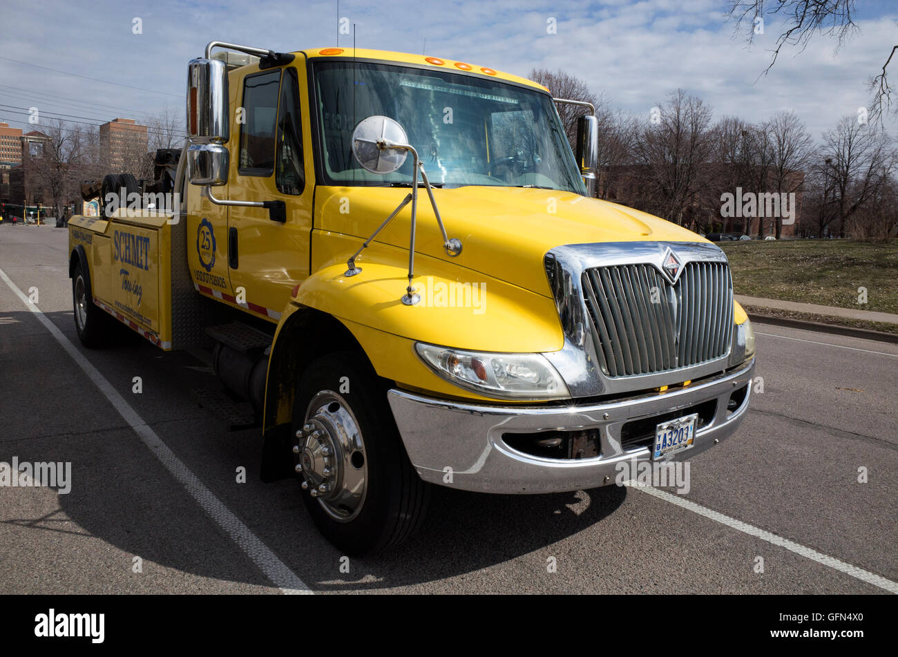 Macho portrait of a pristine yellow tow truck advertising 25 years of 'Shmit Towing'. Minneapolis Minnesota MN USA Stock Photo