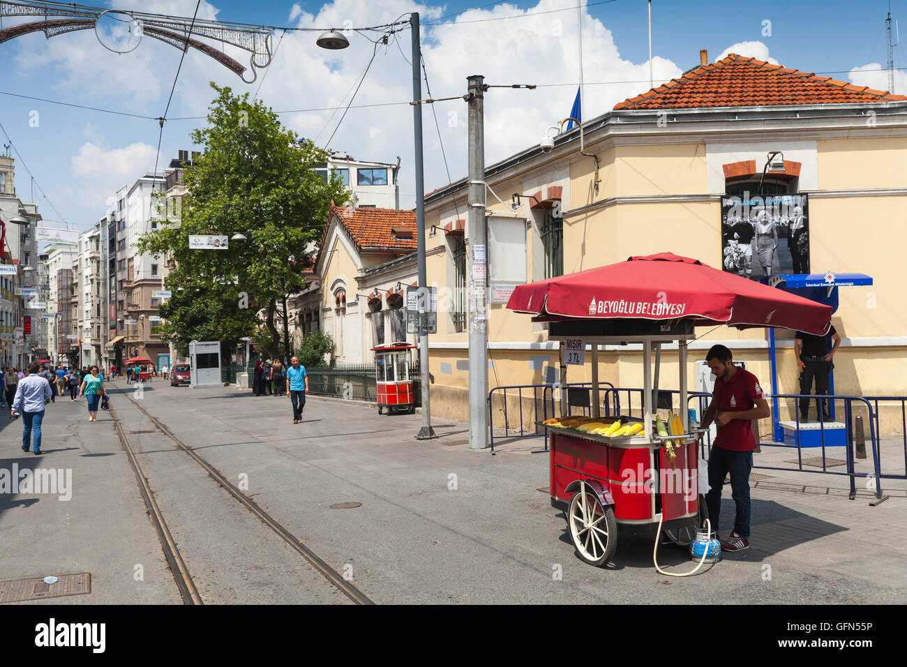 Istanbul, Turkey - July 1, 2016: Seller near red cart with boiled corn and roasted chestnuts, Taksim square, Istiklal street Stock Photo