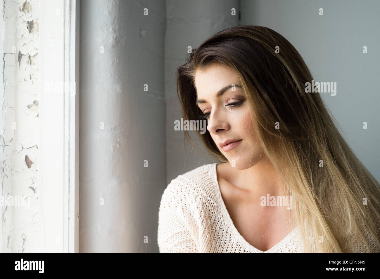 Beautiful young woman with enigmatic smile Stock Photo
