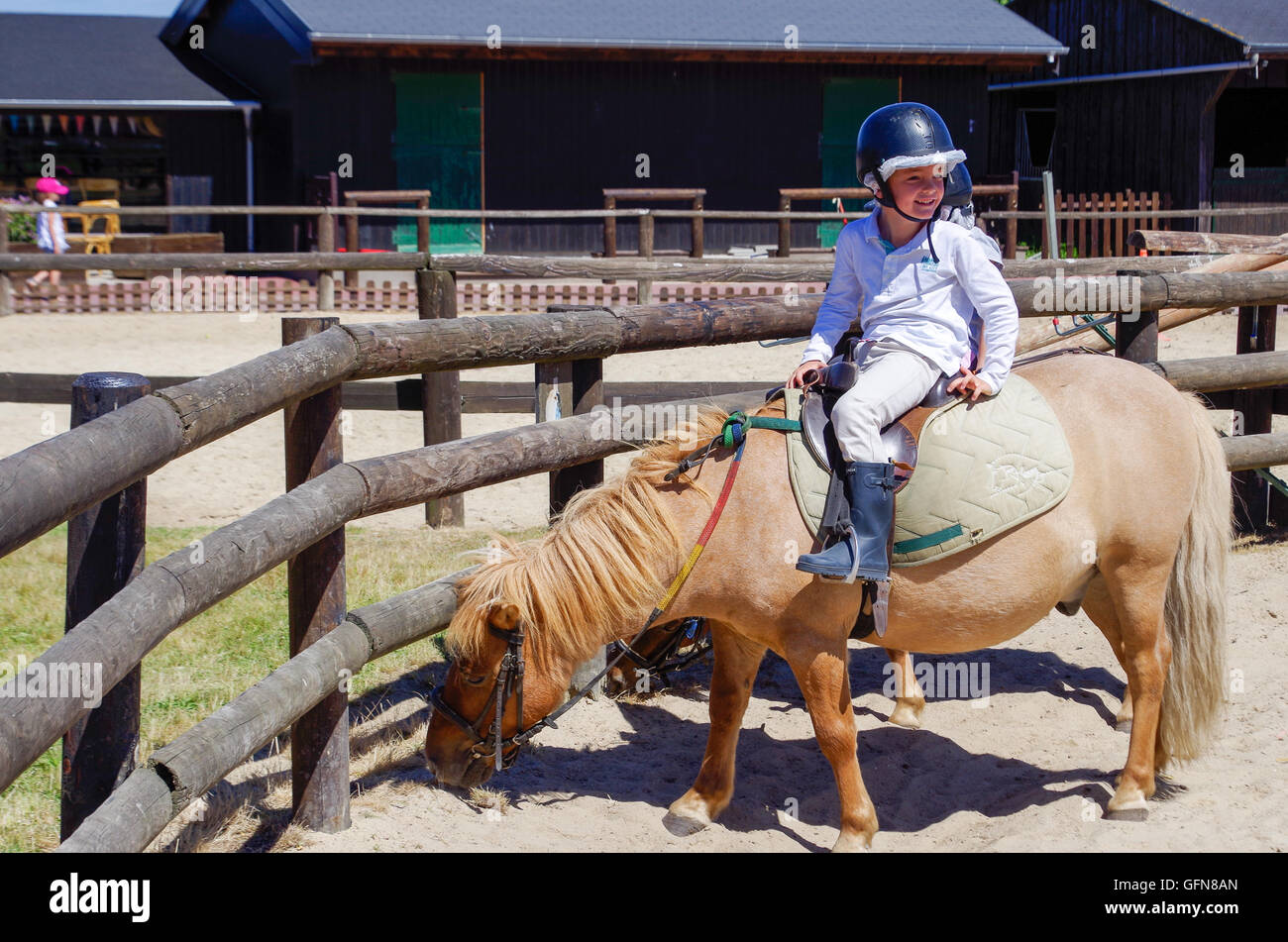 Small boy, smiling and happy, riding on a pony in Deauville, France Stock Photo