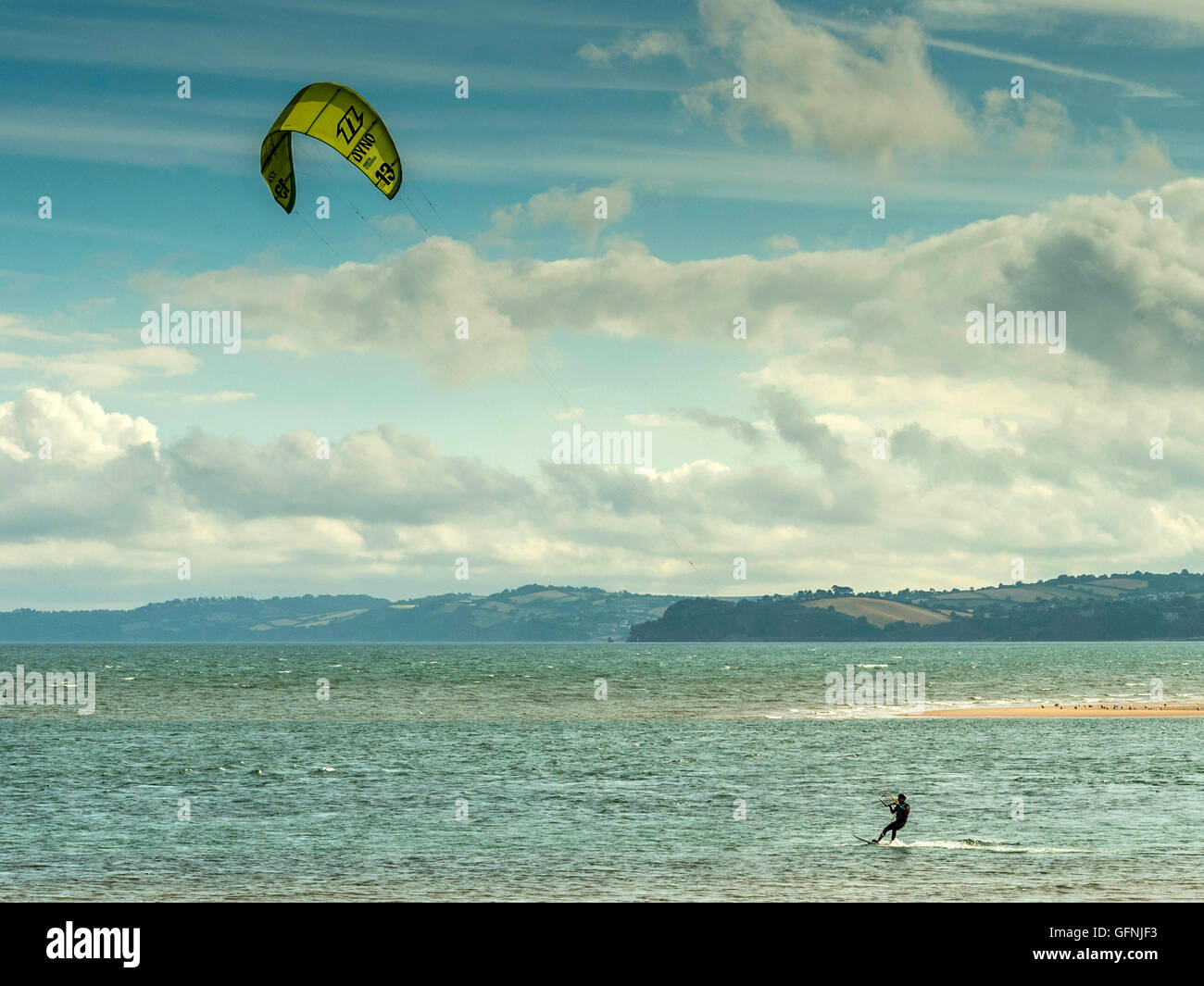 Kite surfing along the beautiful Jurassic seaside coast around the mouth of the River Exe estuary, with blue sea and sky. Stock Photo