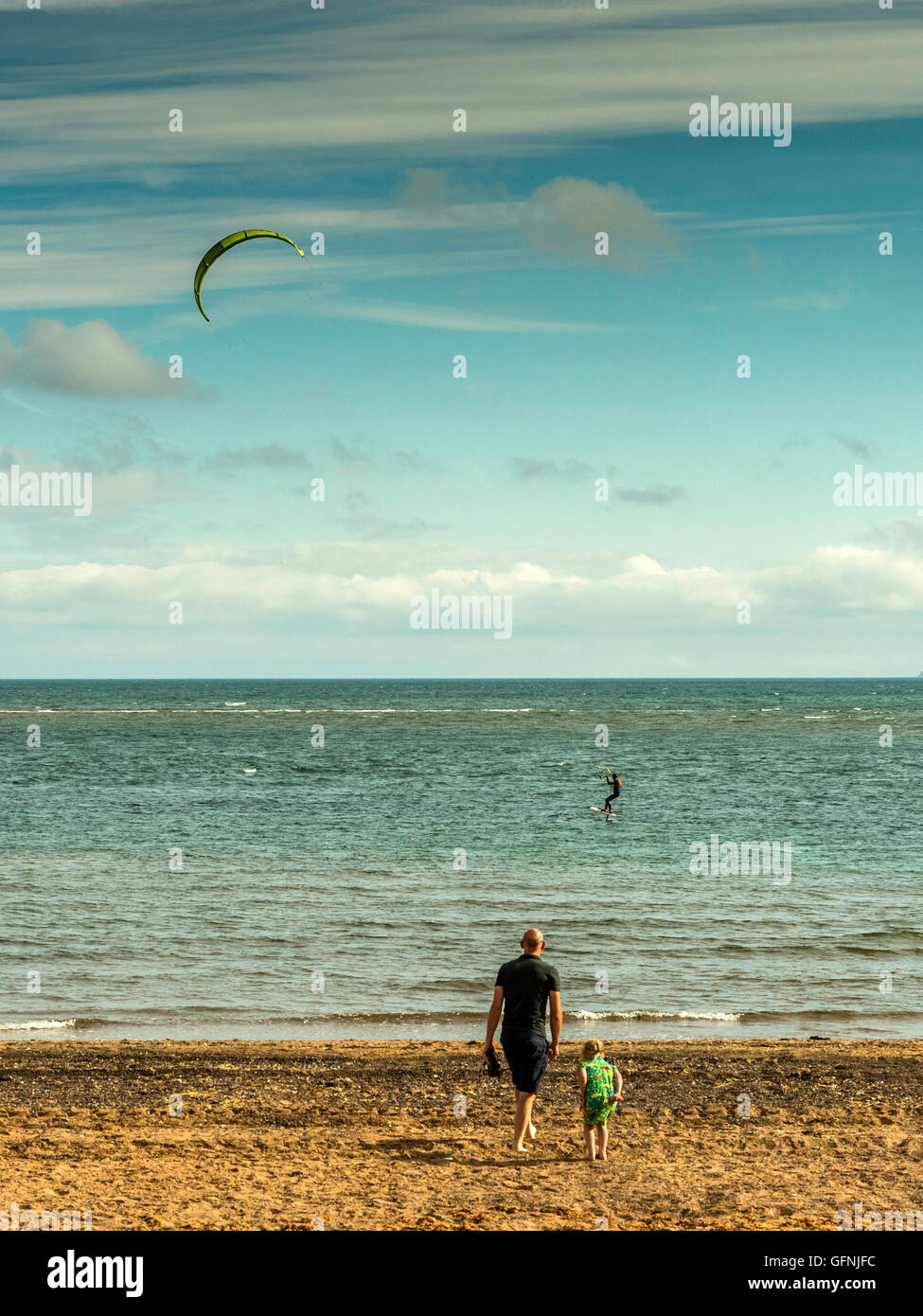 Kite surfing along the beautiful Jurassic seaside coast around the mouth of the River Exe estuary, with blue sea and sky. Stock Photo