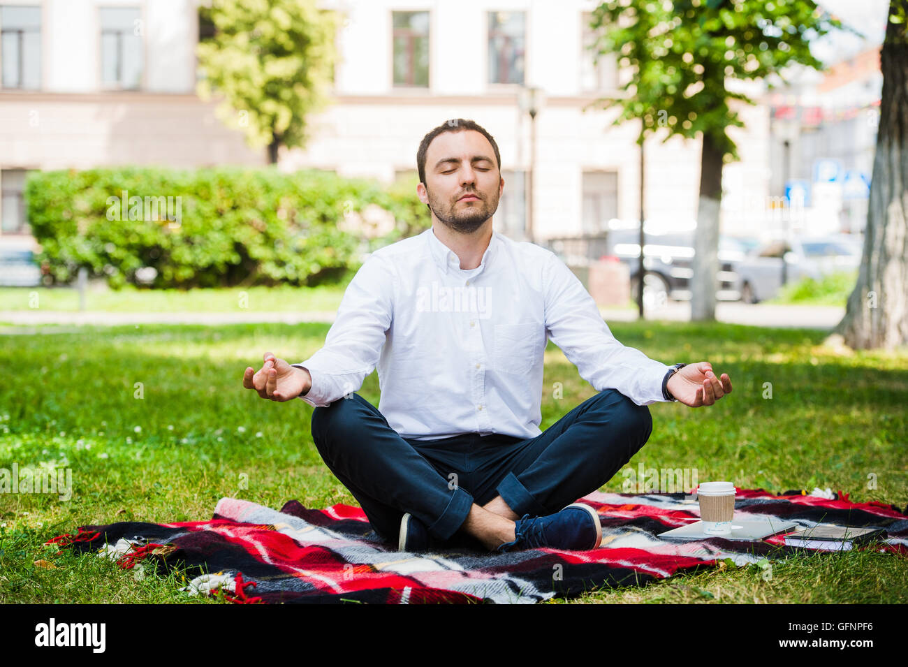 Business man relaxing in a park in the lotus position Stock Photo