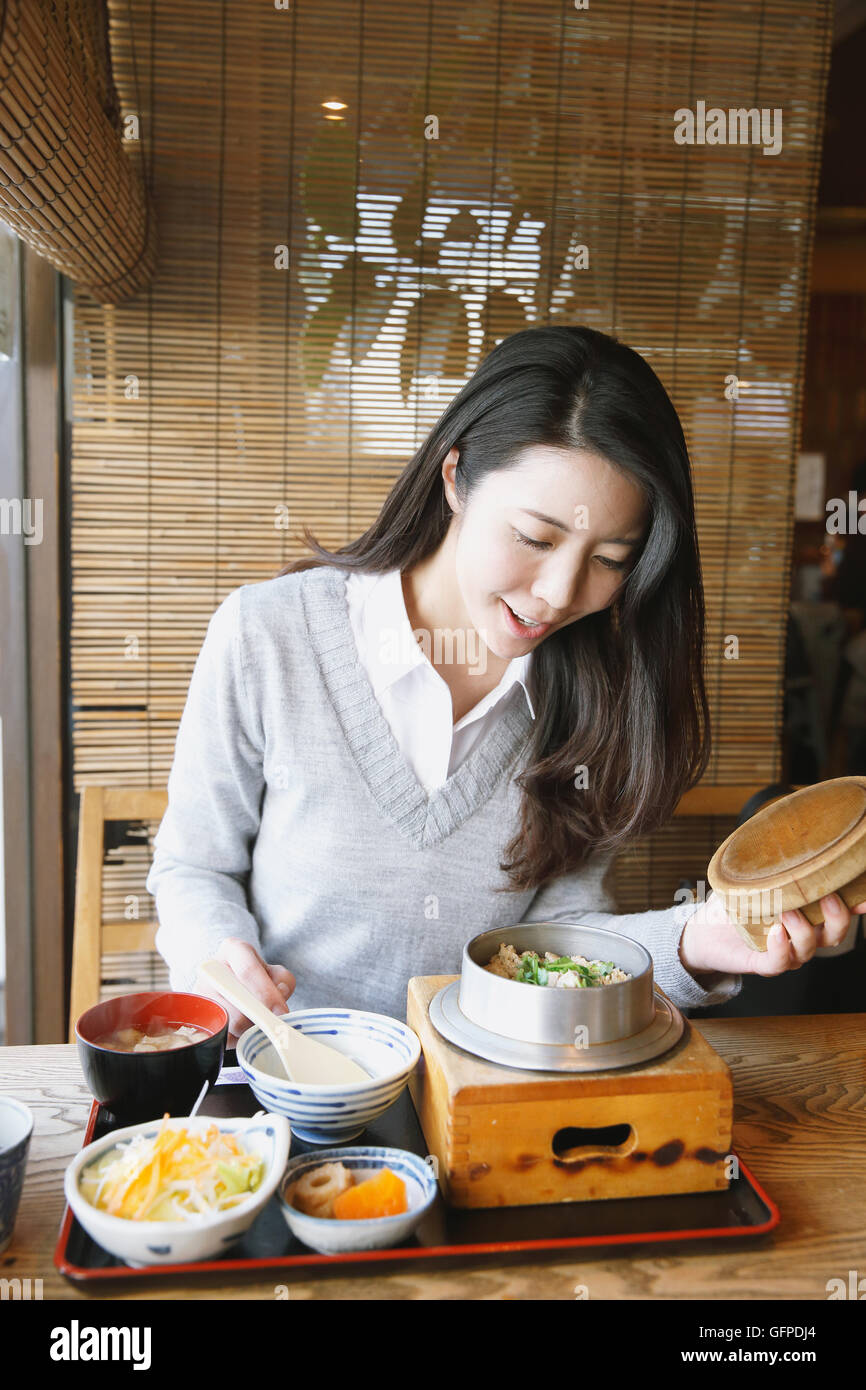 Young attractive Japanese woman eating at the restaurant Stock Photo