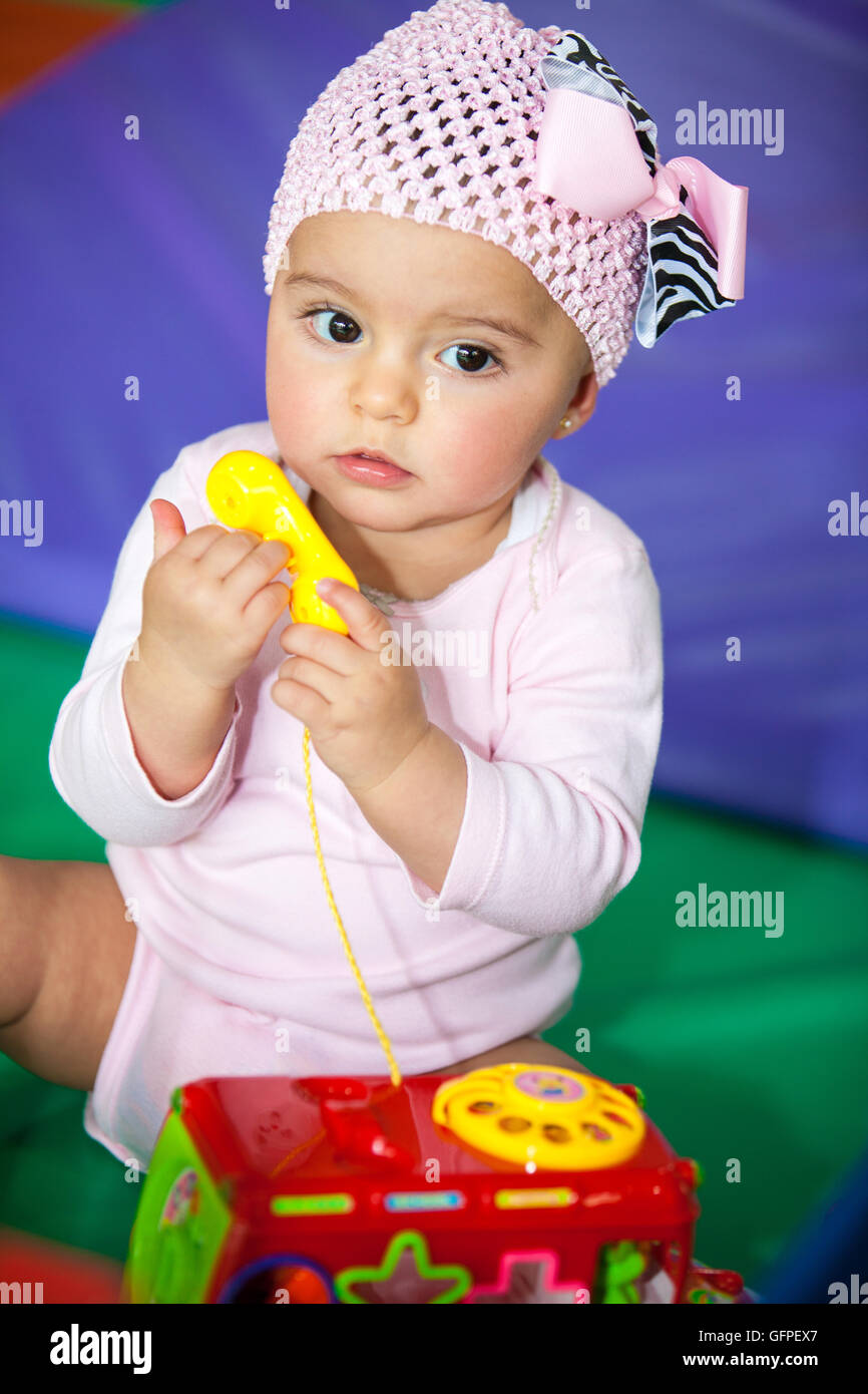 Baby girl playing with the toy phone Stock Photo - Alamy