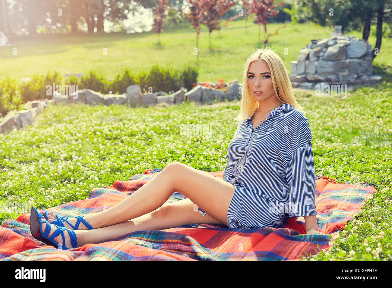 Beautiful young girl resting on the plaid in the park Stock Photo - Alamy