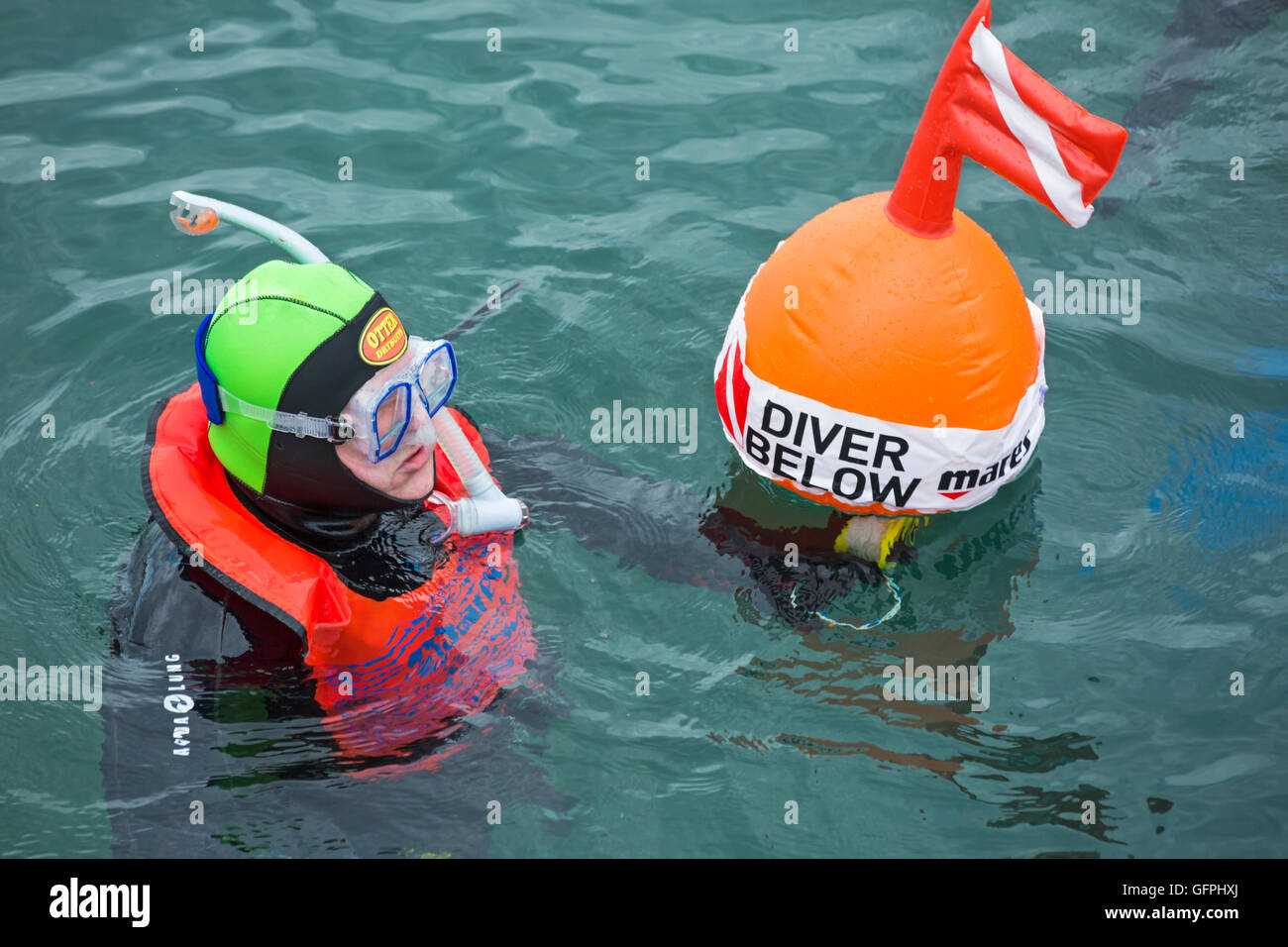 Diver below marker buoy with scuba diver in fluorescent coloured gear