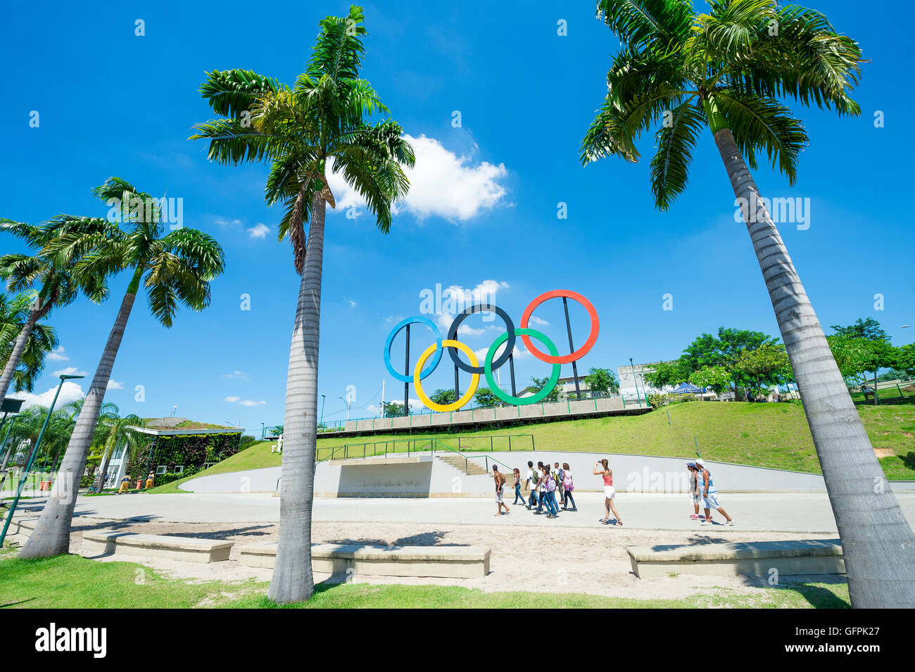 RIO DE JANEIRO - MARCH 18, 2016: Young Brazilians walk in front of Olympic rings installed for the 2016 Summer Games. Stock Photo