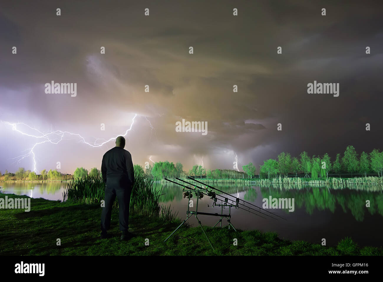 The storm is coming. Man standing in a storm. Man with cloud over his head. Night Fishing in a storm Stock Photo