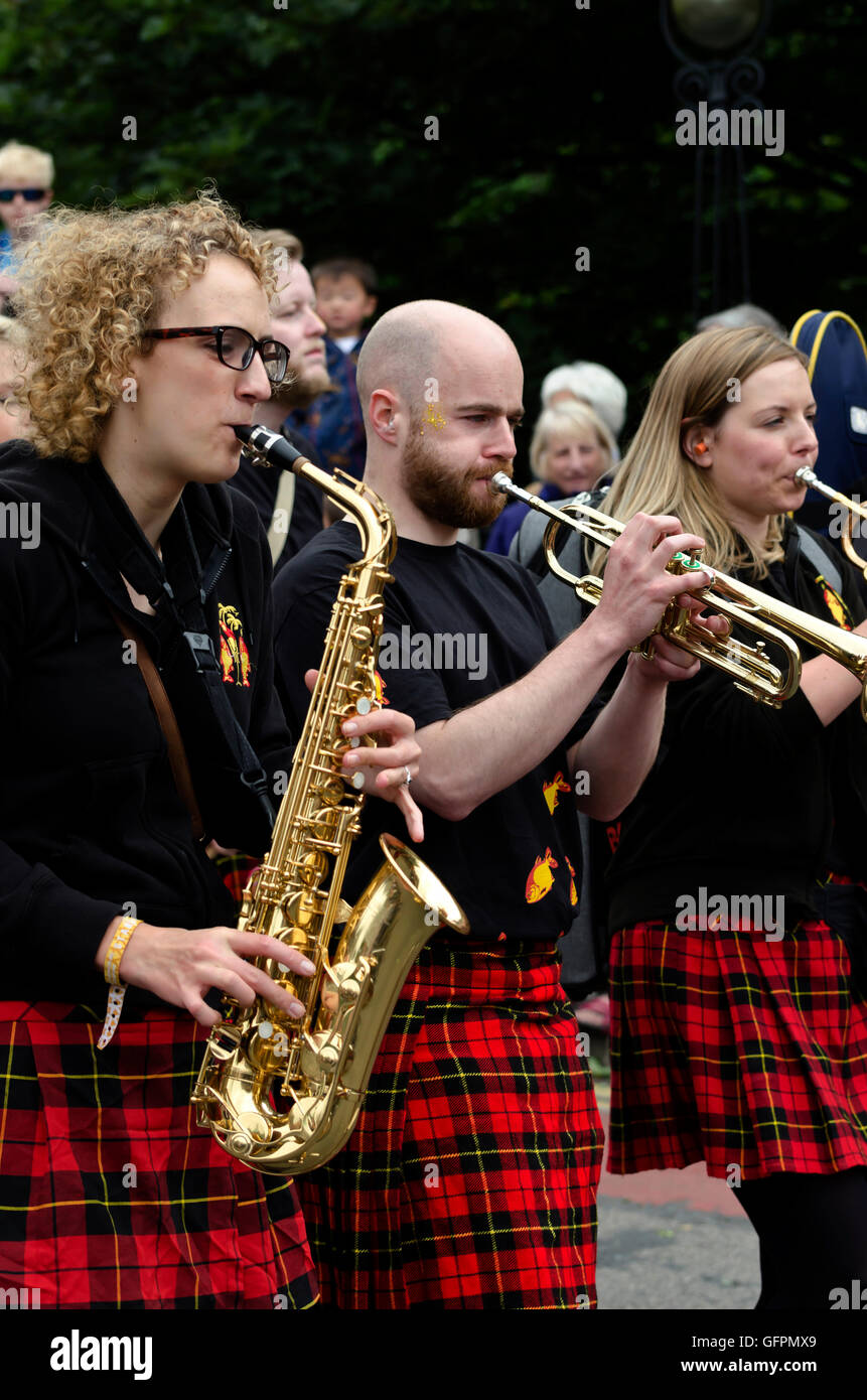 Female sax player and trumpeters with a band taking part in the