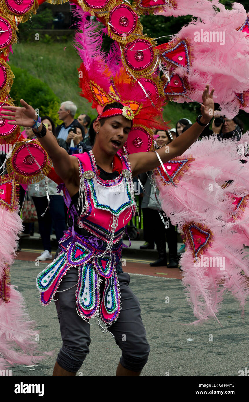 Exotic male dancer with feathered headdress taking part in the Carnival Parade, part of the Edinburgh Jazz Festival. Stock Photo
