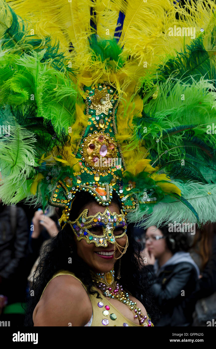 Female dancer in sequinned mask and feathered headdress taking part in the Carnival Parade, part of the Edinburgh Jazz Festival. Stock Photo