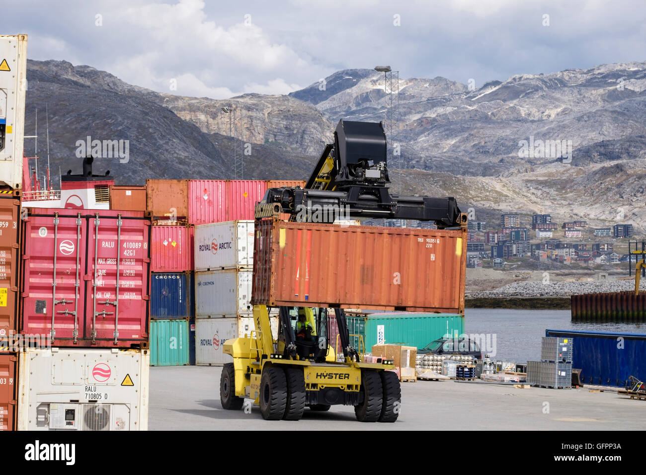 Hydraulic Hyster electric forklift truck lifting freight shipping container in port. Atlantic Harbour Nuuk Sermersooq West Greenland Stock Photo