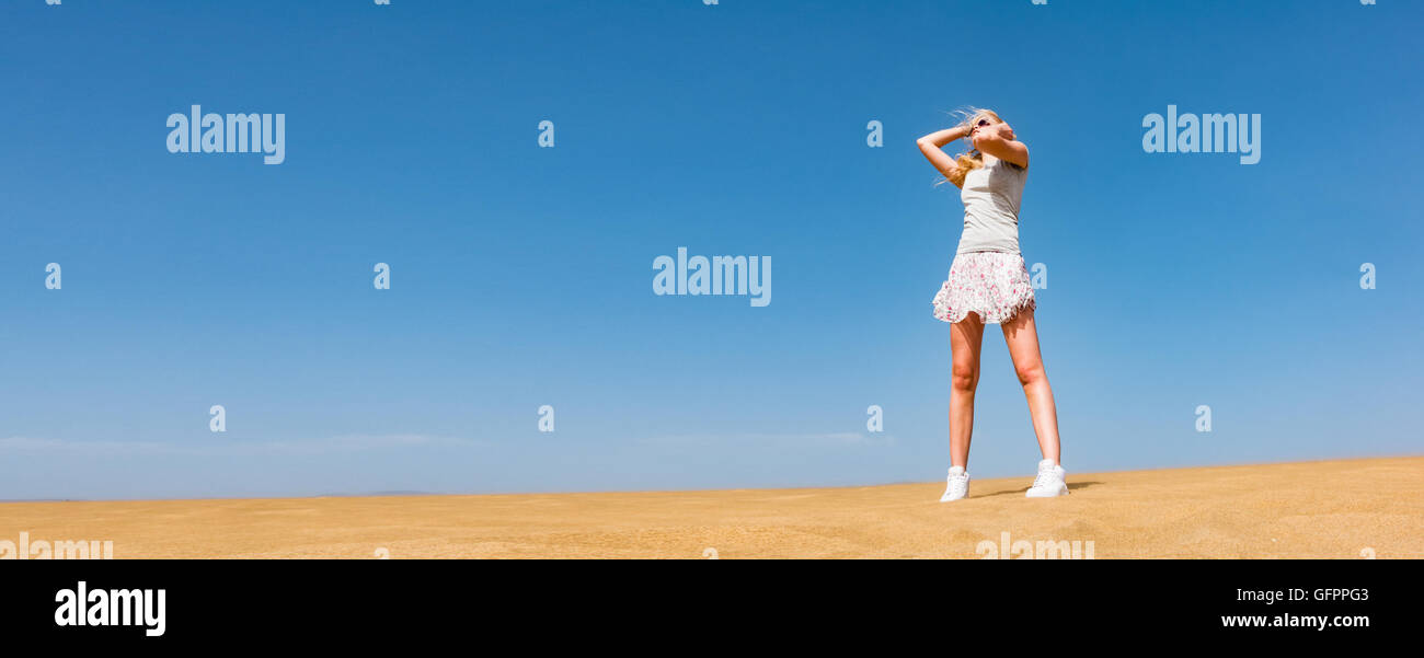 A young woman in sand desert wearing short skirt Stock Photo