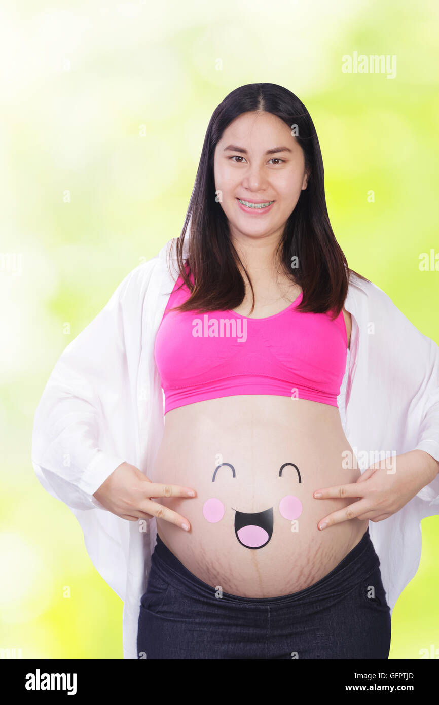 Happy pregnant woman with smiley face on her belly Stock Photo Alamy