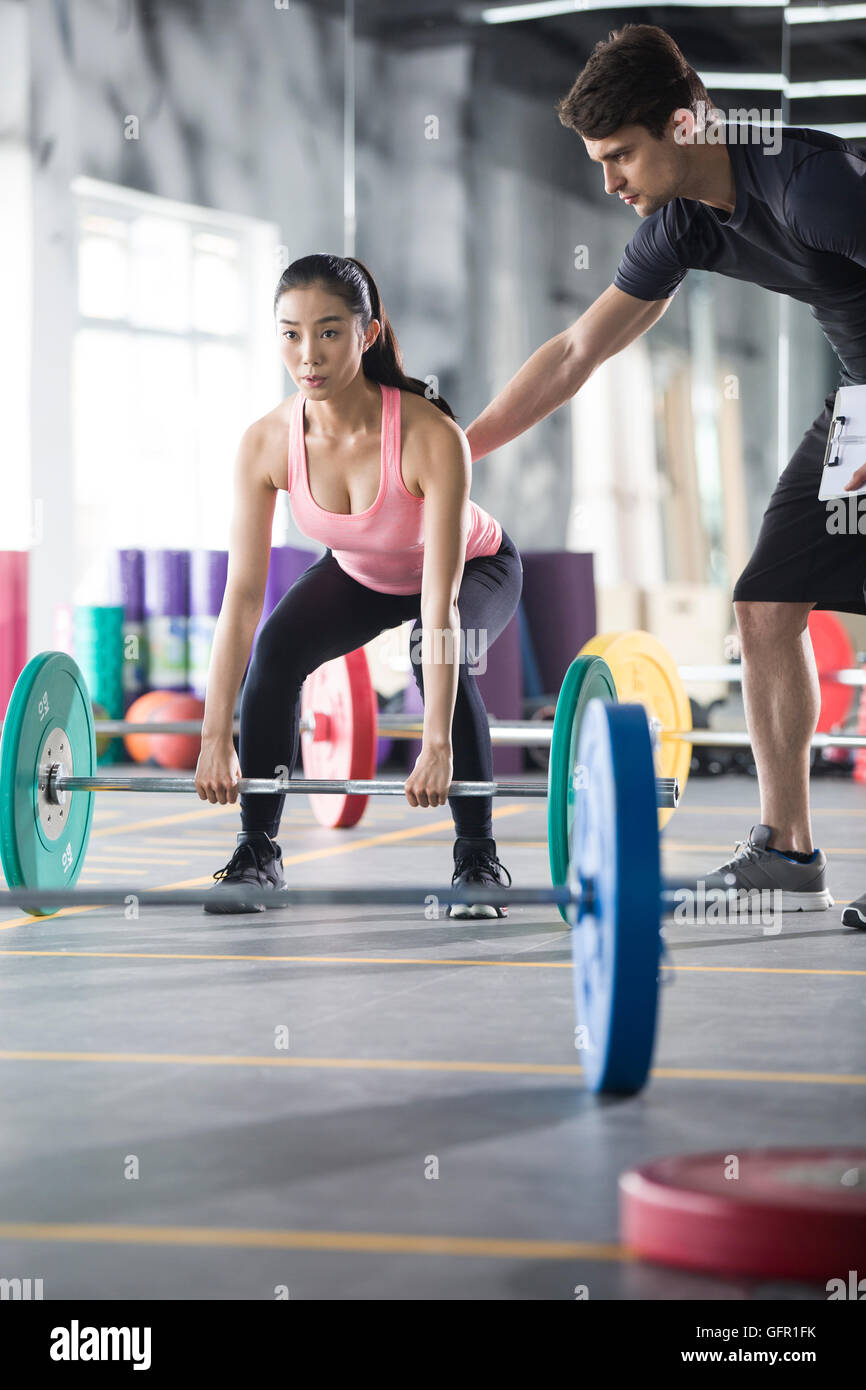 Young Chinese woman working with trainer at gym Stock Photo - Alamy