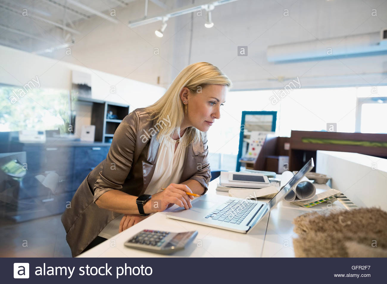 Interior designer working at laptop in home furnishings store Stock