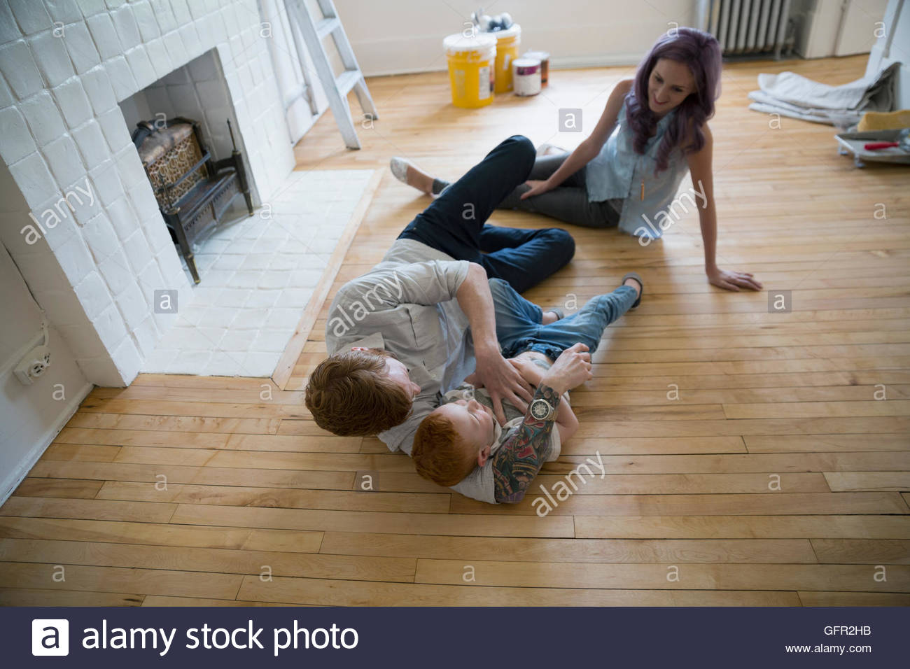 Playful young family tickling on floor in new house Stock Photo Alamy