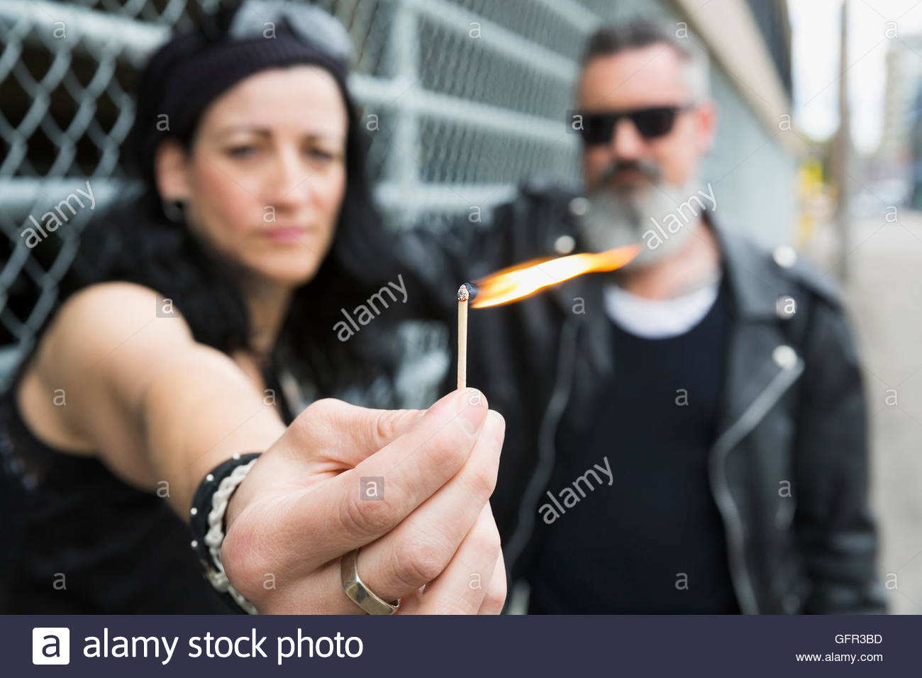 Portrait cool mature couple holding lit matchstick Stock Photo